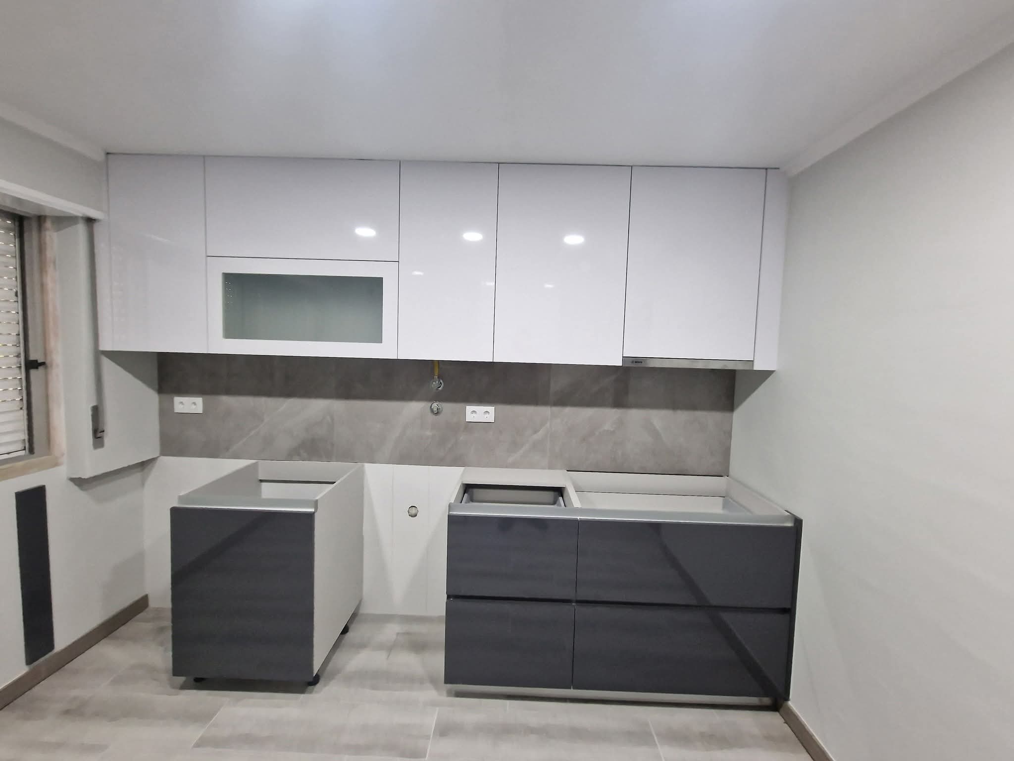 Cozinha finalizada com bancada preta e armários brancos